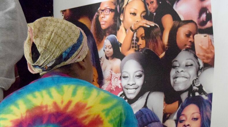 Sanmarian McClain looks at photos of her 18-year-old daughter, Jessica, who was killed Thursday.