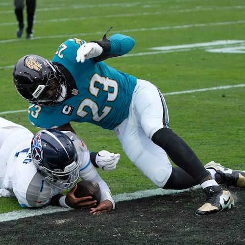 Tennessee Titans quarterback Cam Ward (1) scores a touchdown as he is hit by Jacksonville Jaguars linebacker Foyesade Oluokun (23) during the first half of an NFL football game Sunday, Jan. 4, 2026, in Jacksonville, Fla. (AP Photo/John Raoux)