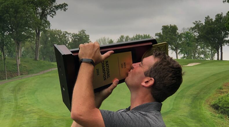 Dalton State coach Ben Rickett smooches the 2021 NAIA national championship trophy his team won in Illinois in dramatic fashion.