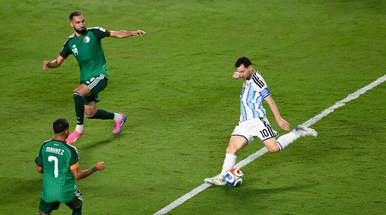 Argentina's Lionel Messi (10) shoots and scores their third goal against Algeria's Riyad Mahrez (7) and Nabil Bentaleb (19) during the World Cup Group J soccer match between Argentina and Algeria in Kansas City, Mo., Tuesday, June 16, 2026. (AP Photo/Reed Hoffmann)