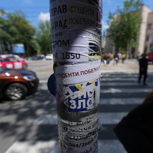 People walk by a lamppost with stickers that read: "Students win" before the first big rally this year of opponents of President Aleksandar Vucic in Belgrade, Serbia, Monday, May 18, 2026. (AP Photo/Darko Vojinovic)