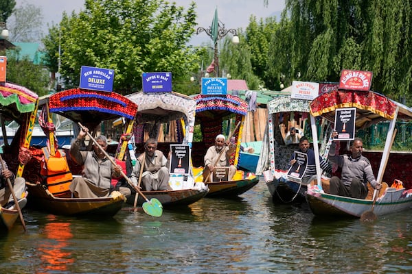 Kashmiri boatmen hold placards as they condemn the tourists killing at Dal Lake in Srinagar, Indian controlled Kashmir, Thursday, April. 24, 2025. (AP Photo/Mukhtar Khan)