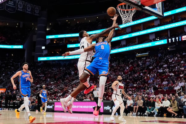 Houston Rockets forward Jabari Smith Jr. (10) fouls Oklahoma City Thunder forward Jalen Williams (8) during the first half of an NBA basketball game in Houston, Friday, April 4, 2025. (AP Photo/Ashley Landis)