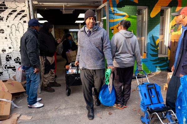 Mikole Harden, a STEM teacher at Scott Elementary School, pulls a cart out of the Grocery Spot on Wednesday, Nov. 16, 2022. The Grocery Spot is a community-supported free grocery that has recently started opening its doors to school teachers and staff. Harden, who made a donation for his groceries, said the store, where he gets things for his classroom as well as for his family, has helped him cut his grocery bill in half. (Ben Gray for The Atlanta Journal-Constitution)