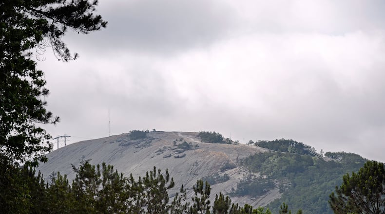 Clouds in the morning light partially obscure a radio tower atop Stone Mountain.