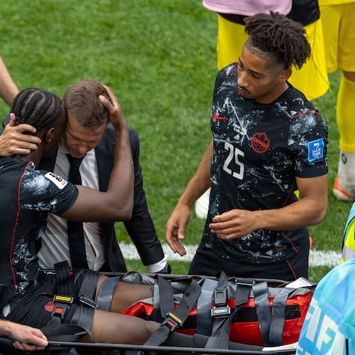 Canada head coach Jesse Marsch embraces Ismael Kone (8) as he is stretchered off the field after an injury during the World Cup Group B soccer match between Canada and Qatar in Vancouver, British Columbia, Thursday, June 18, 2026. (Timothy Matwey/The Canadian Press via AP)