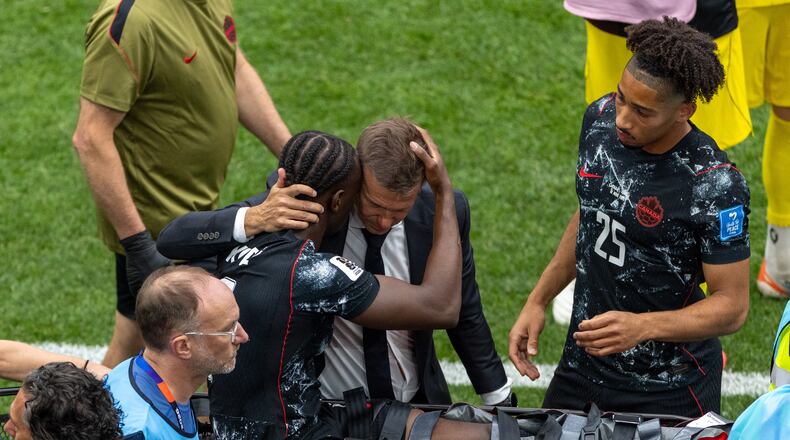 Canada head coach Jesse Marsch embraces Ismael Kone (8) as he is stretchered off the field after an injury during the World Cup Group B soccer match between Canada and Qatar in Vancouver, British Columbia, Thursday, June 18, 2026. (Timothy Matwey/The Canadian Press via AP)