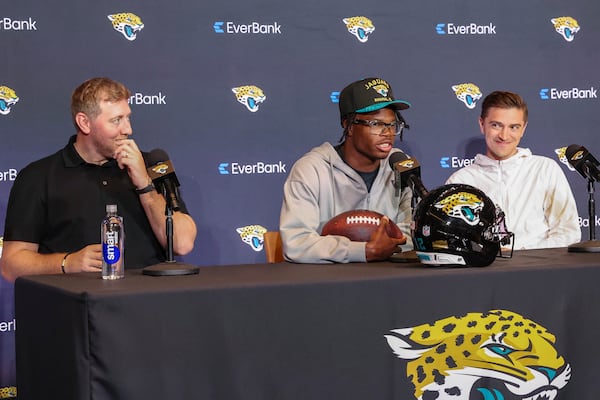 Two-way player Travis Hunter, the Jacksonville Jaguars first round draft pick, second overall, talks with reporters, flanked by general manager James Gladstone, right, and head coach Liam Coen, left, during an NFL football press conference, Friday, April 25, 2025, in Jacksonville, Fla. (AP Photo/Gary McCullough)
