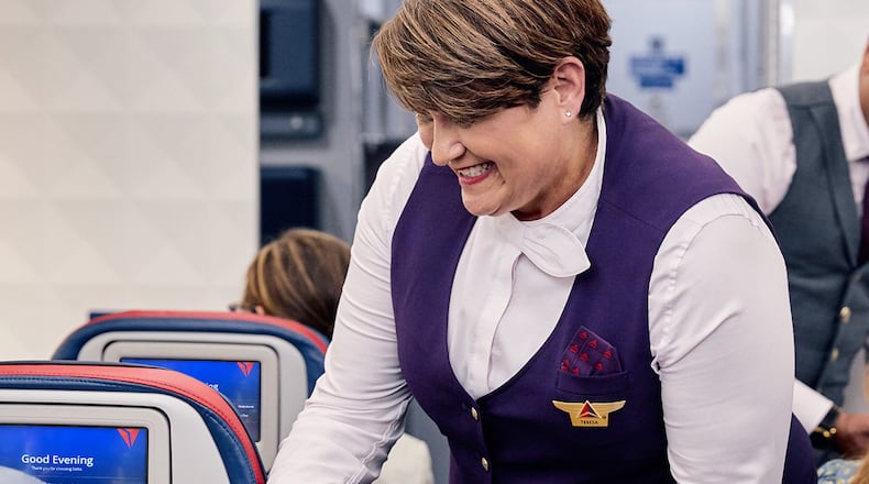 A Delta flight attendant serves a customer. Delta Air Lines CEO Ed Bastian announced that it will add a sign language pin as an option for employee uniforms in the fall.