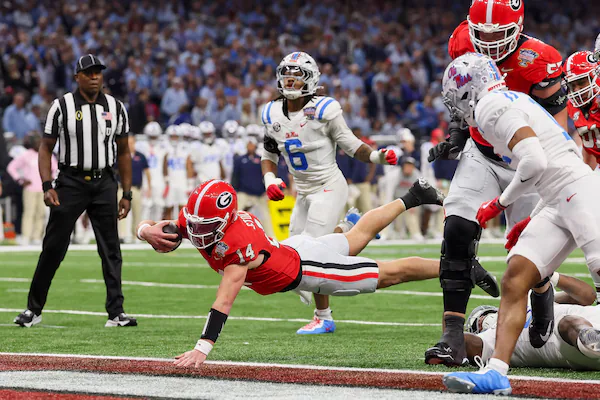 Georgia Bulldogs quarterback Gunner Stockton (14) dives into the end zone for a 12 yard touchdown run against the Ole Miss Rebels during the second quarter of the NCAA College Football Playoff quarterfinal game at the Sugar Bowl in the Caesars Superdome, Thursday, Jan. 1, 2026, in New Orleans. (Jason Getz/AJC)