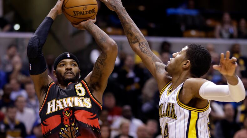 Atlanta Hawks forward Josh Smith, left, shoots over Indiana Pacers forward Paul George during the first half of an NBA basketball game in Indianapolis, Tuesday, Feb. 5, 2013. (AP Photo/Michael Conroy)