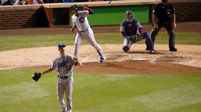 Chicago Cubs' Javier Baez watches his home run off Los Angeles Dodgers starting pitcher Alex Wood (57) during the fifth inning of Game 4 of baseball's National League Championship Series, Wednesday, Oct. 18, 2017, in Chicago. (AP Photo/Charles Rex Arbogast)