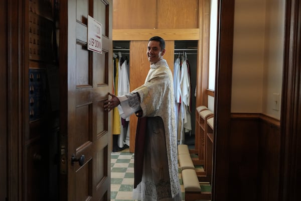 The Rev. Alfredo Tuesta opens the door to the sacristy after a Mass at St. James Catholic Church, Falls Church, Va., on Sunday, May 24, 2025. (AP Photo/Luis Andres Henao)