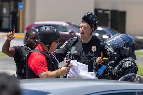 Police tell Spanish-language reporter Mario Guevara to move back during a protest against President Donald Trump’s immigration policies on Chamblee Tucker Road on Saturday, June 14, 2025, in Atlanta. (Arvin Temkar/AJC)