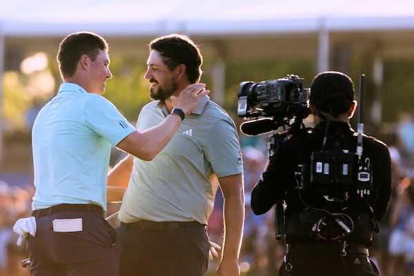Andrew Novak embraces teammate Ben Griffin, left, on the 18th green after they won the PGA Zurich Classic golf tournament at TPC Louisiana in Avondale, La., Sunday, April 27, 2025. (AP Photo/Gerald Herbert)