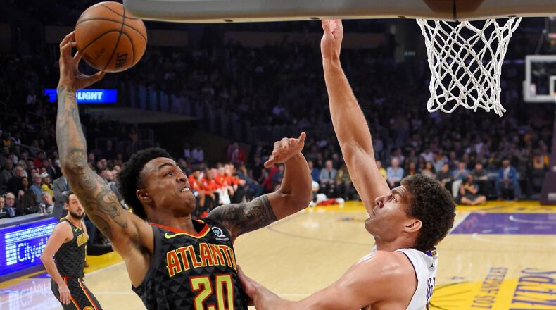 Atlanta Hawks forward John Collins, left, shoots as Los Angeles Lakers center Brook Lopez defends during the first half of a basketball game, Sunday, Jan. 7, 2018, in Los Angeles. (AP Photo/Mark J. Terrill)