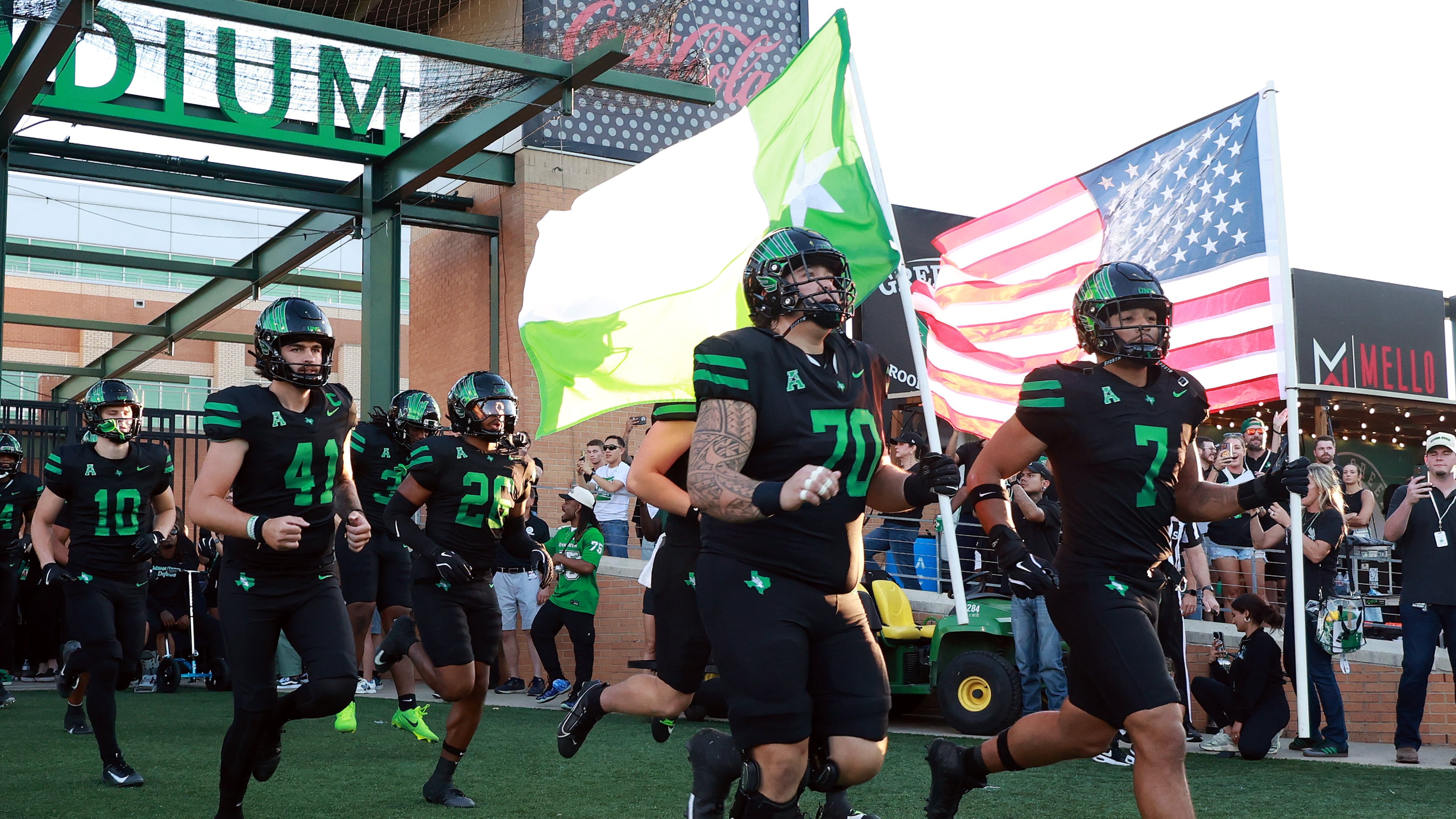 FILE - North Texas offensive lineman Tay Yanta II (70) and North Texas linebacker Shane Whitter (7) lead the team onto the field before an NCAA college football game against South Florida Oct. 10, 2025, in Denton, Texas. (AP Photo/Richard W. Rodriguez, File)