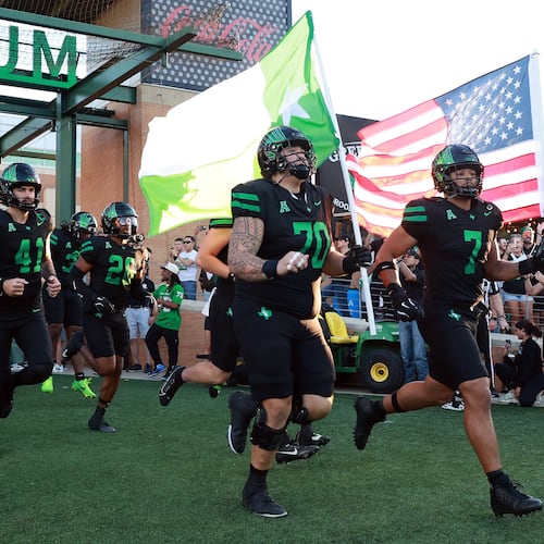 FILE - North Texas offensive lineman Tay Yanta II (70) and North Texas linebacker Shane Whitter (7) lead the team onto the field before an NCAA college football game against South Florida Oct. 10, 2025, in Denton, Texas. (AP Photo/Richard W. Rodriguez, File)