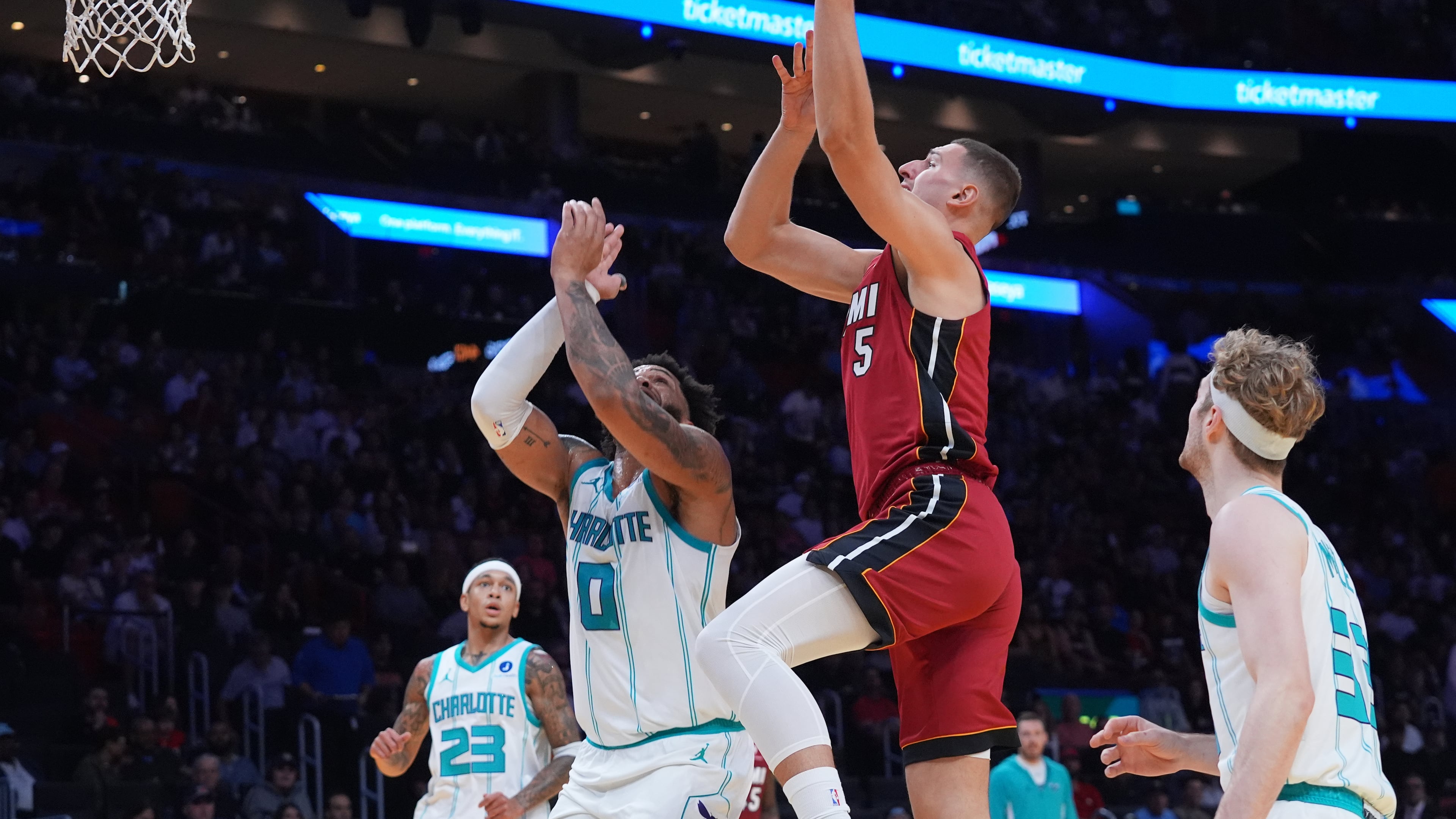 Miami Heat guard Pelle Larsson (9) drives to the basket over Charlotte Hornets forward Miles Bridges (0) during the first half of an NBA Cup basketball game Friday, Nov. 7, 2025, in Miami. (AP Photo/Marta Lavandier)