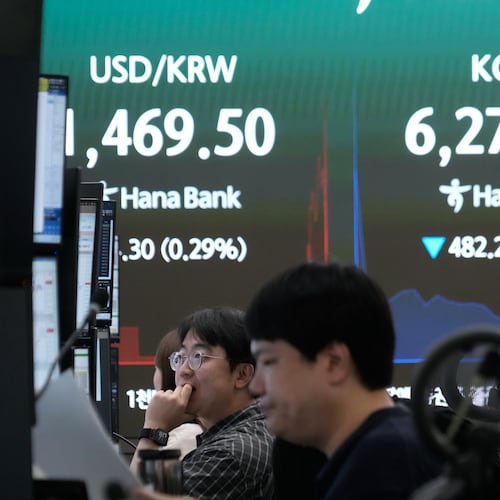 Currency traders watch monitors near a screen showing the Korea Composite Stock Price Index (KOSPI) and the foreign exchange rate between U.S. dollar and South Korean won at the foreign exchange dealing room of the Hana Bank headquarters in Seoul, South Korea, Tuesday, July 28, 2026. (AP Photo/Ahn Young-joon)