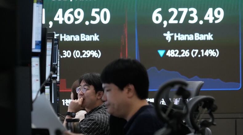 Currency traders watch monitors near a screen showing the Korea Composite Stock Price Index (KOSPI) and the foreign exchange rate between U.S. dollar and South Korean won at the foreign exchange dealing room of the Hana Bank headquarters in Seoul, South Korea, Tuesday, July 28, 2026. (AP Photo/Ahn Young-joon)