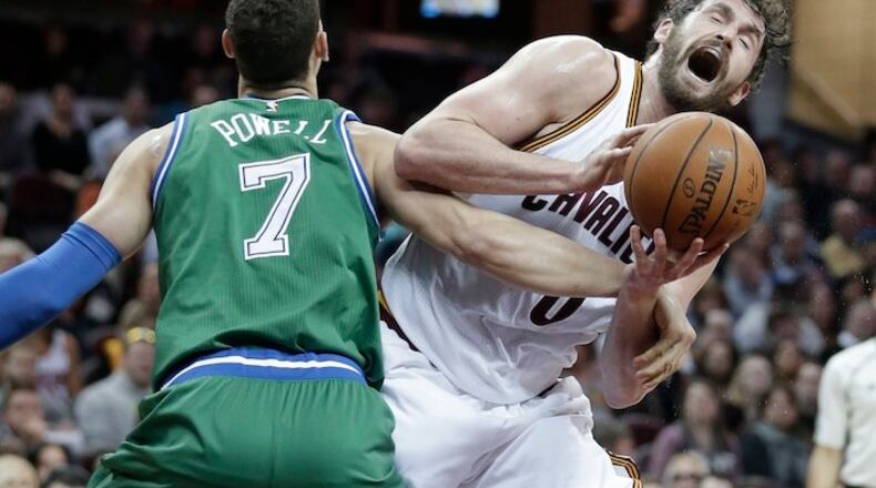 Dallas Mavericks' Dwight Powell (7) fouls Cleveland Cavaliers' Kevin Love (0) in the first half of an NBA basketball game Wednesday, March 16, 2016, in Cleveland. (AP Photo/Tony Dejak)