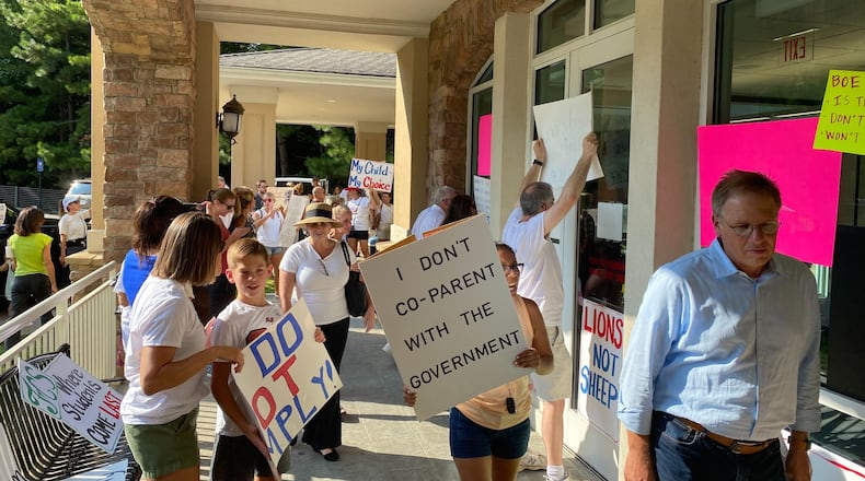 People opposed to Fulton County Schools' mask mandate protest outside a board meeting on Aug. 13, 2021. VANESSA McCRAY/AJC FILE PHOTO