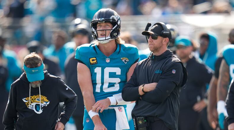 Jacksonville Jaguars quarterback Trevor Lawrence (16) stands next to head coach Liam Coen during the first half of an NFL wild-card playoff football game against the Buffalo Bills Sunday, Jan. 11, 2026, in Jacksonville, Fla. (AP Photo/John Raoux)