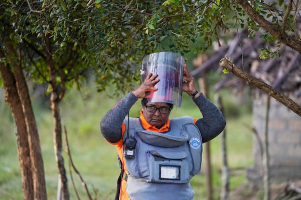 Thavarathnam Pushparani, 56, puts on her protective gear to work in a contaminated mining area in Mankulam, Sri Lanka, Thursday, April 3, 2025. (AP Photo/Eranga Jayawardena)