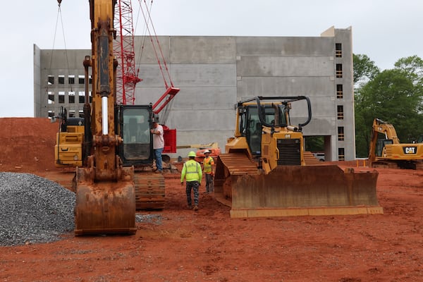 Workers build a parking deck on the site of the former Varsity restaurant on West Broad Street in Athens on Friday, April 25, 2025. A mixed-use development that will include a supermarket is scheduled to open in summer 2027. (C.J. Bartunek for The Atlanta Journal-Constitution)
