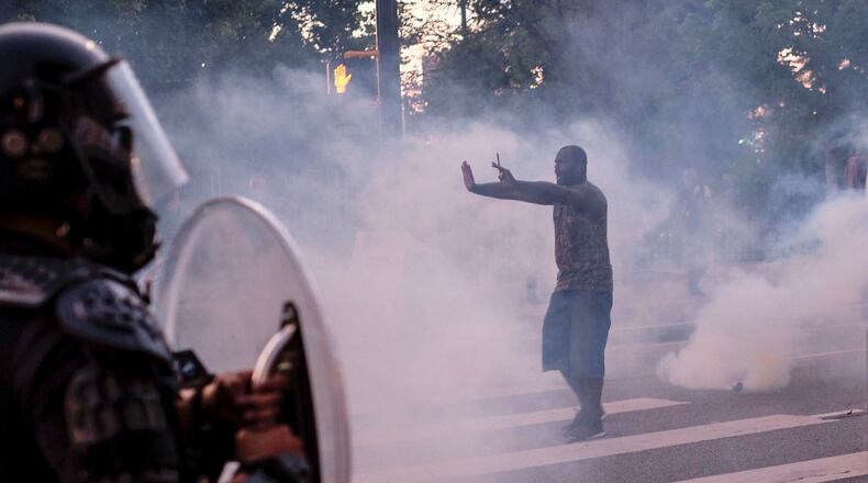 A protestor tries to talk the police back amid tear gas in downtown Atlanta as protests continued for a third day. Protests over the death of George Floyd in Minneapolis police custody continued around the United States, as his case renewed anger about others involving African Americans, police and race relations. Ben Gray for the Atlanta Journal Constitution