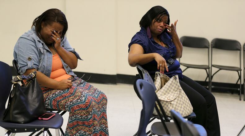 Parents Keisha Spells, left, and Renee Sewell cry after an emotional meeting where the Latin Academy charter school board voted to close the school Thursday evening May 5, 2016. Ben Gray / bgray@ajc.com
