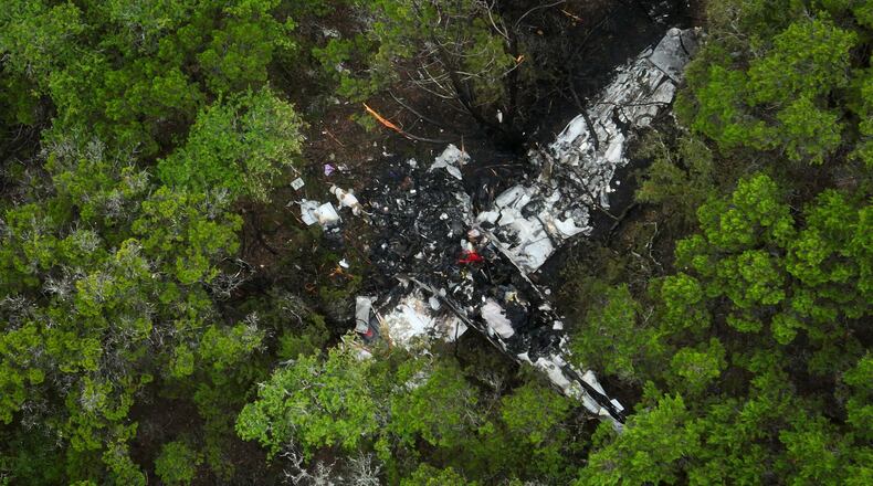 A crashed Cessna airplane is seen in a wooded area on Round Rock Road in Wimberley, Texas, Friday, May 1, 2026. (Jay Janner/Austin American-Statesman via AP)