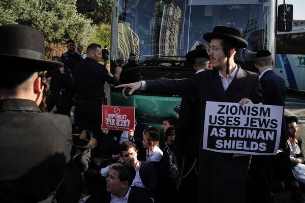 Ultra-Orthodox Jewish men block a highway during a protest against army recruitment in Bnei Brak, Israel, Thursday, June 5, 2025. (AP Photo/Leo Correa)