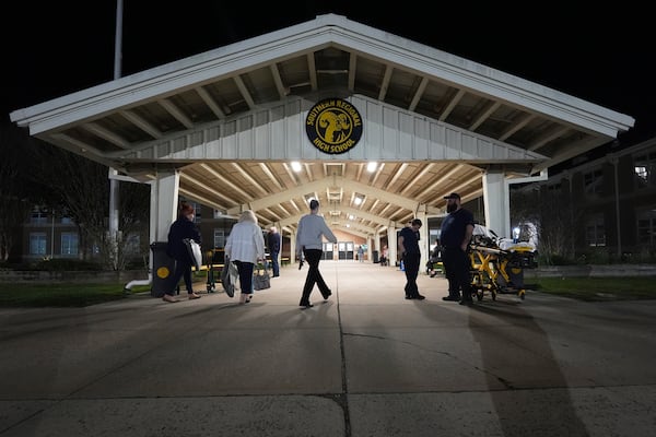 People head into an evacuation shelter at Southern Regional High School from wildfires on Tuesday, April 22, 2025, near Stafford Township, N.J. (AP Photo/Chris Szagola)