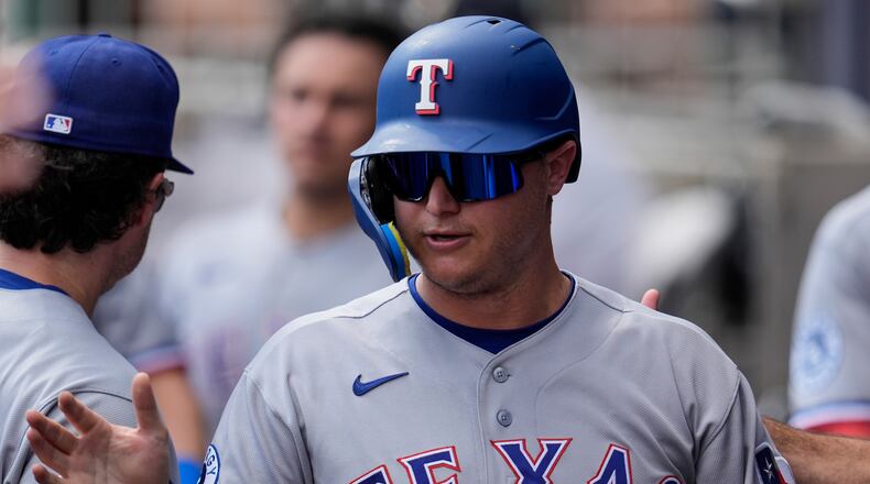 Texas Rangers designated hitter Joc Pederson (3) celebrates scoring off the bat of Brandon Nimmo in the third inning of a baseball game against the Atlanta Braves, Saturday, July 18, 2026, in Atlanta. (AP Photo/Mike Stewart)