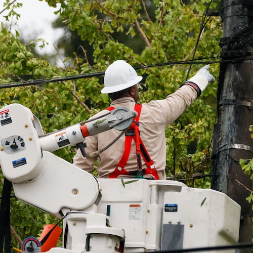 A worker works on power lines at Hill Street in Grant Park. The average customer will save $4.04 monthly thanks to agreement between the PSC and Georgia Power. (Miguel Martinez/AJC)