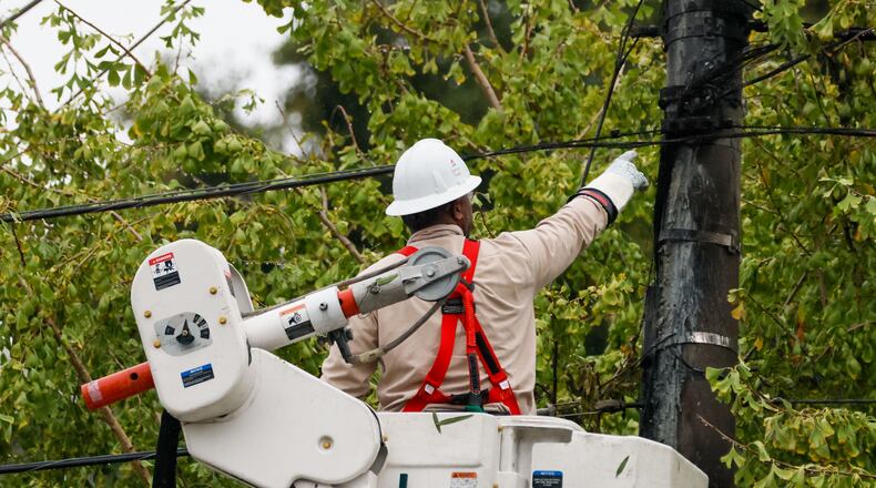 A worker works on power lines at Hill Street in Grant Park. The average customer will save $4.04 monthly thanks to agreement between the PSC and Georgia Power. (Miguel Martinez/AJC)