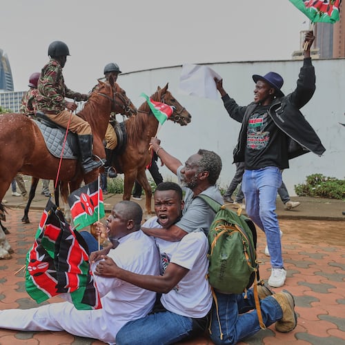 Protesters sing and wave Kenyan flags near Parliament during a demonstration marking two years since the 2024 anti-government protests in Nairobi, Kenya, Thursday, June 25, 2026. (AP Photo/Henry Naminde)
