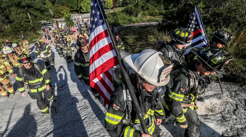 Wearing full firefighting gear, about 200 metro Atlanta area firefighters honored the firefighters, paramedics and law enforcement officers who lost their lives on Sept. 11, 2001, by ascending Stone Mountain in 2001. (John Spink / AJC FILE PHOTO)