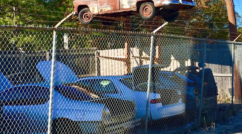 This ancient Volkswagon, referenced several times during the April 16 Decatur city commission meeting, hovers over a junkyard that’s one of 11 properties petitioning the city for annexation. The long-range plan is to turn those properties into a mixed use development featuring 289 apartments. But portions of the plan were deferred by the commission Monday night. Bill Banks file photo for the AJC