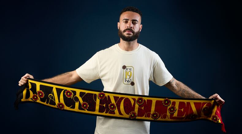 Atlanta United’s Derrick Williams unfurls the team’s Juneteenth scarf, which is part of the Legacy Collection.
