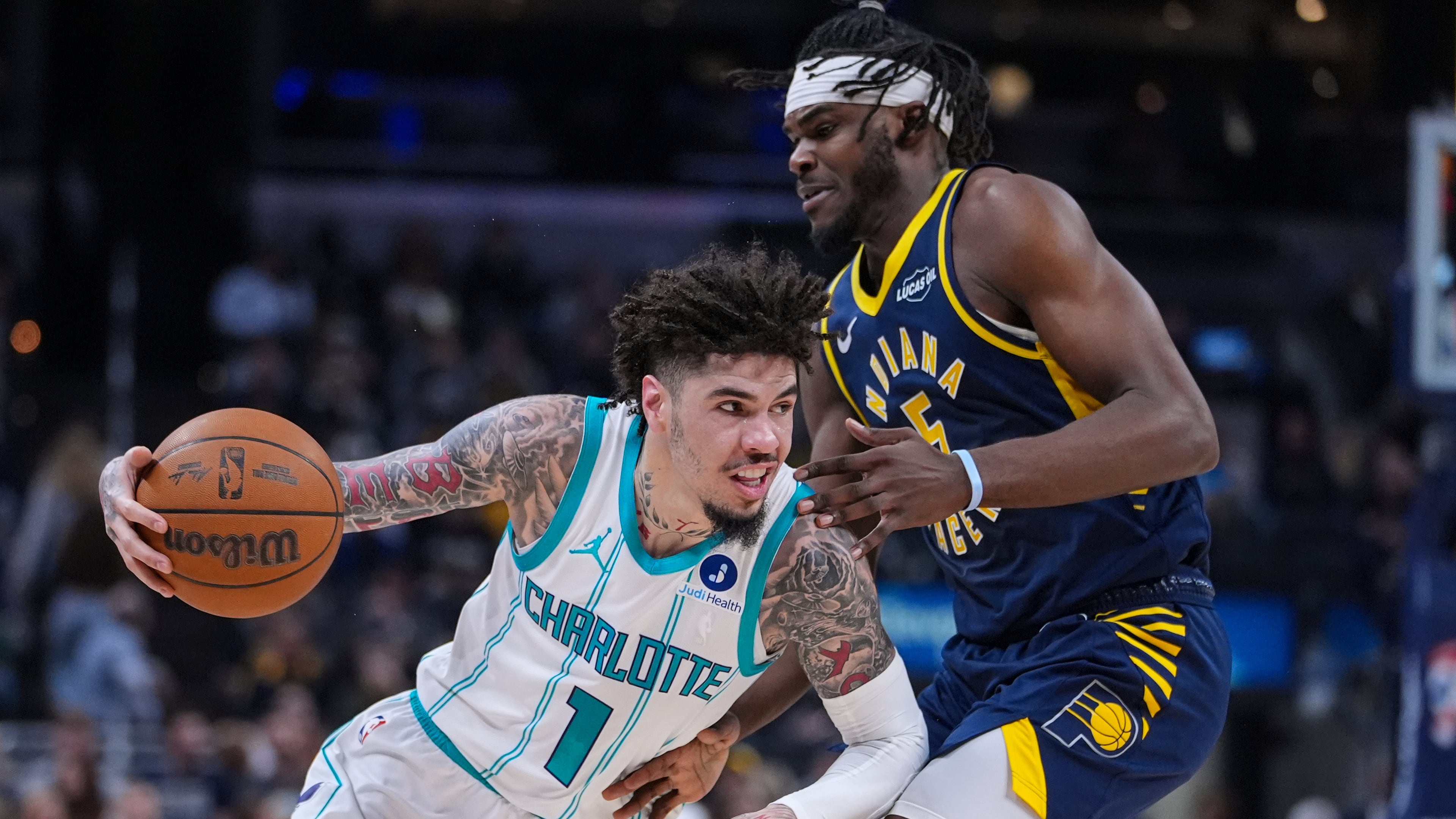 Charlotte Hornets guard Lamelo Ball (1) drives on Indiana Pacers forward Jarace Walker (5) during the first half of an NBA basketball game in Indianapolis, Wednesday, Nov. 19, 2025. (AP Photo/Michael Conroy)