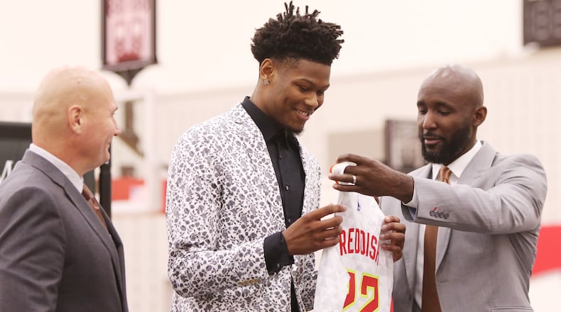Cam Reddish (middle), a Hawks 2019 draft pick, receives his official Atlanta Hawks number, 22, and jersey from Atlanta Hawks General Manager Travis Schlenk (left) and Atlanta Hawks Coach Lloyd Pierce (right) at his introductory press conference at the Hawks practice facility, in the Emory Sports Medicine Complex, in Brookhaven, Georgia on Monday June 24, 2019. Reddish was selected by the Atlanta Hawks in the 2019 NBA Draft on  June 20, 2019, and was the 10th overall pick. Reddish previously played small forward/shooting guard for the Duke University Blue Devils. Christina Matacotta/CHRISTINA.MATACOTTA@AJC.COM