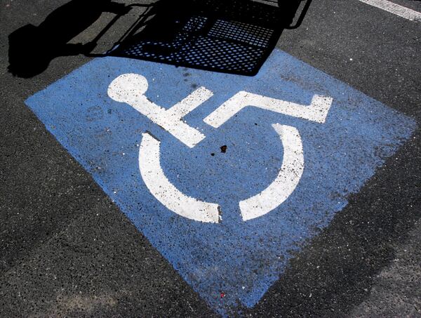 FILE - The shadow of a person with a shopping cart appears on a disability parking space in Brunswick, Maine, on Friday, April 21, 2006. (AP Photo/Pat Wellenbach,File)