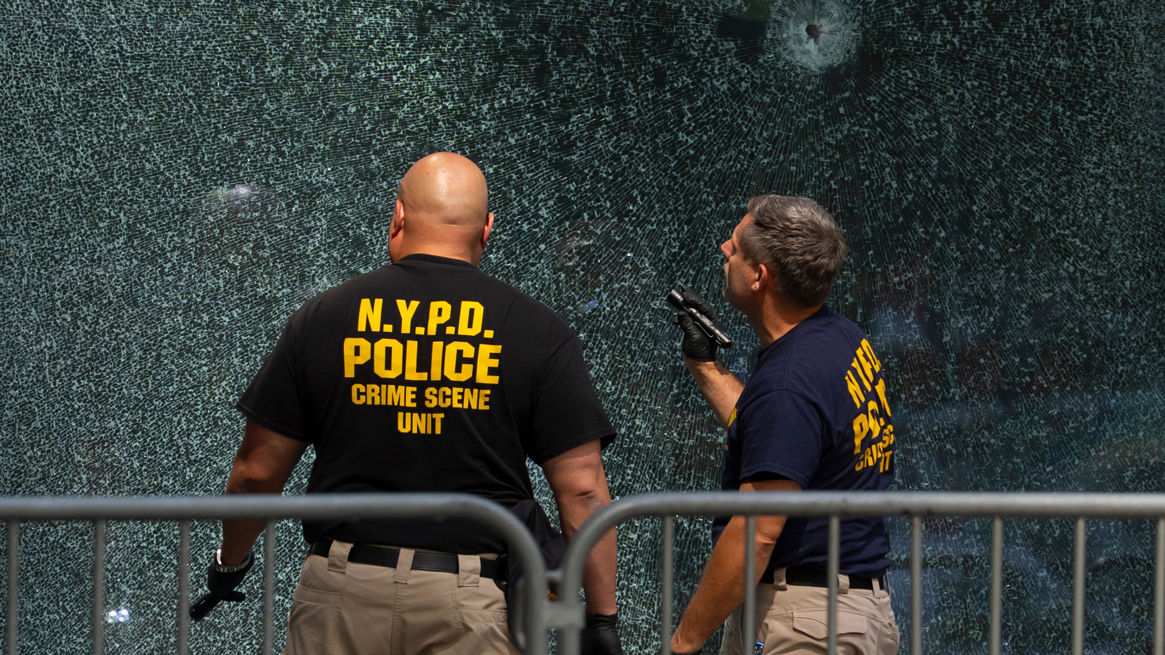 FILE - Members of the NYPD's Crime Scene Unit examine a door with bullet holes, Tuesday, July 29, 2025, in New York, the day after a deadly shooting. (AP Photo/Yuki Iwamura, File)
