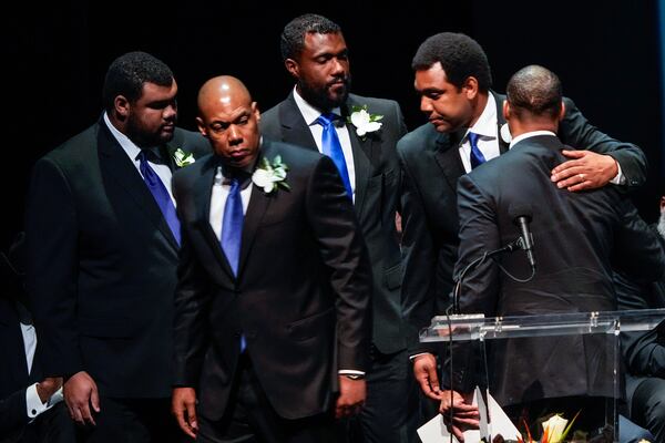 George Foreman IV, right embraces his brothers as they leave the stage following the eulogy for their father during a memorial service for Olympic and world champion boxer and minister George Foreman at Wortham Theater Center in Houston, Monday, April 14, 2025. (Brett Coomer/Houston Chronicle via AP)