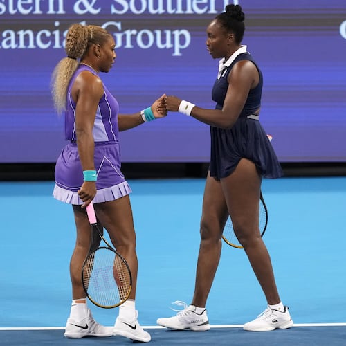 Serena Williams, left, first bumps Venus Williams, right, both of the United States, during a women's doubles match against Marta Kostyuk, of Ukraine, and Peyton Stearns, also of the United States, at the Cincinnati Open tennis tournament, Monday, Aug. 17, 2026, in Mason, Ohio. (AP Photo/Kareem Elgazzar)