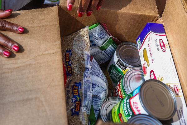 Outside of the King Center, droves of volunteers sorted through boxes of chicken, fresh produce and shelf-stable items on Saturday, Nov. 15, 2025, organizing them for pickup. (Abbey Cutrer/AJC)
