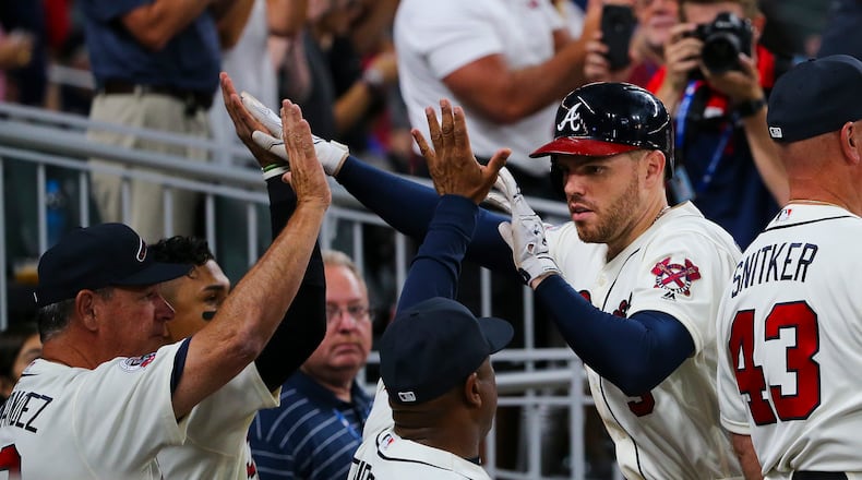 Atlanta Braves' Freddie Freeman (5), second from right, is greeted as he returns to the dugout after hitting a three-run home run in the seventh inning of a baseball game against the Miami Marlins, Saturday, Aug. 5, 2017, in Atlanta. (AP Photo/John Bazemore)